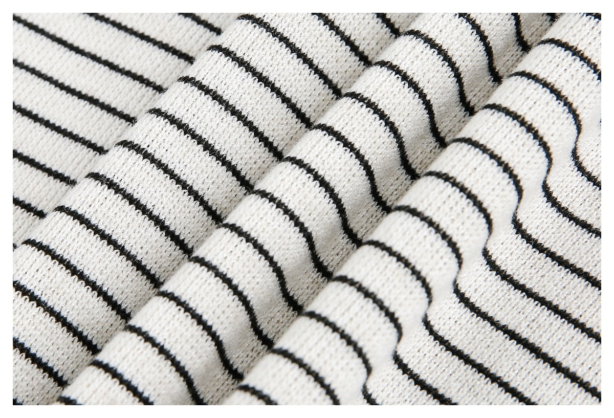 Close-up of white knit fabric with narrow black horizontal stripes and visible ribbed texture.