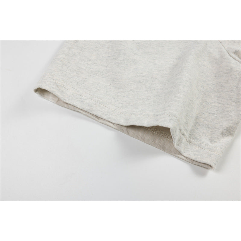 Close-up of the short sleeve opening and stitching on a light heather gray T-shirt.