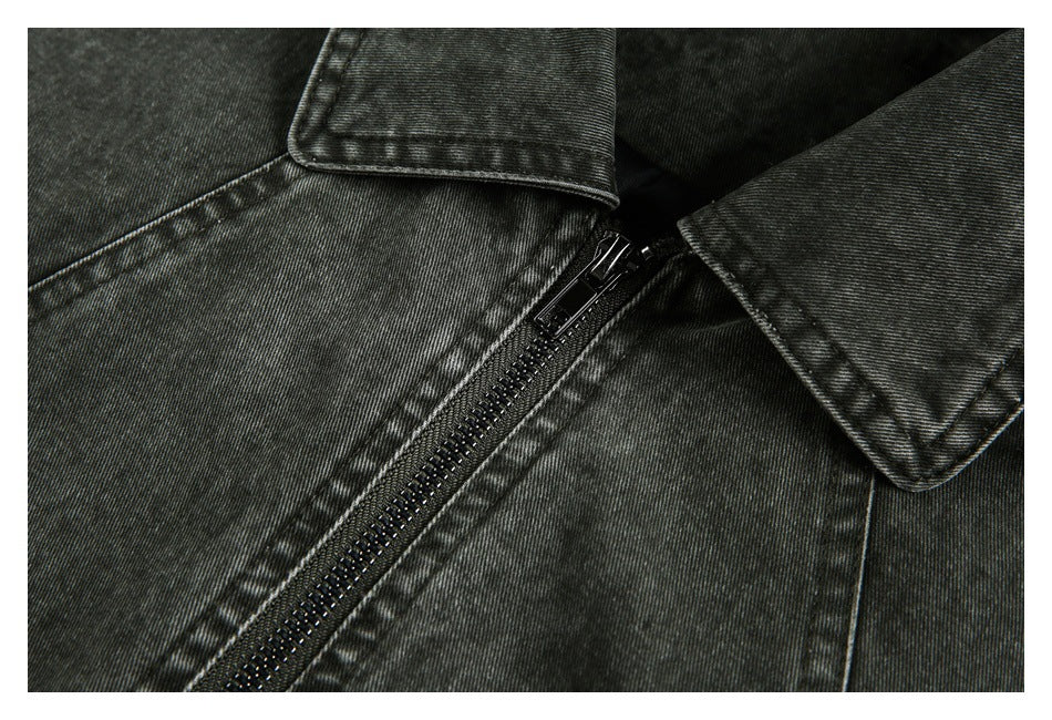 Close-up of the jacket's black front zipper, stitching, and pointed collar edges.