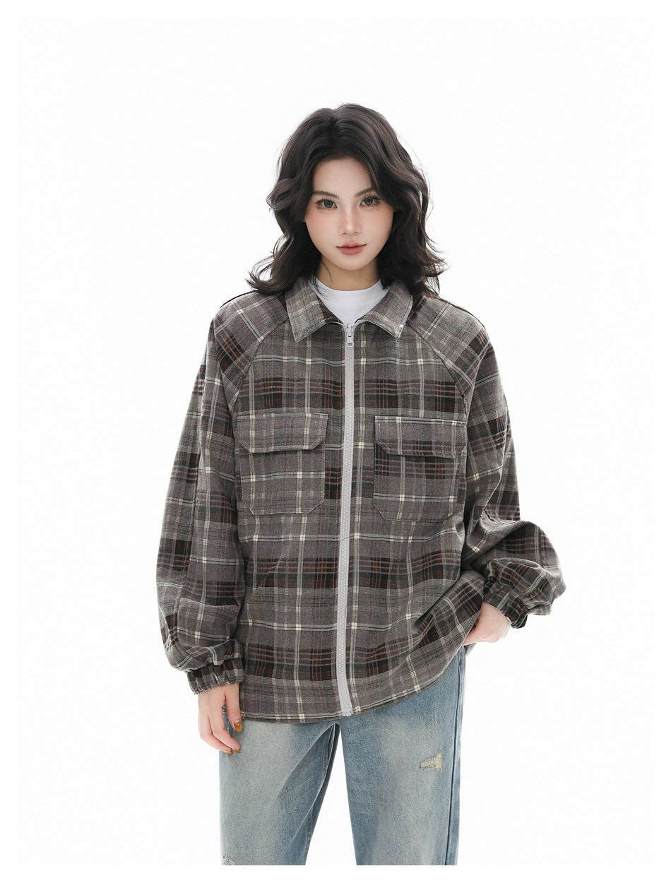 Model wearing a gray plaid zip-front jacket with a pointed collar, flap chest pockets and gathered cuffs.