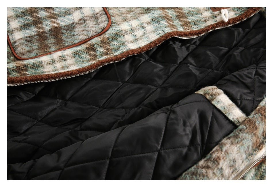 Close-up of a jacket's black diamond-quilted lining, zipper, and mottled multicolor outer fabric with brown trim.