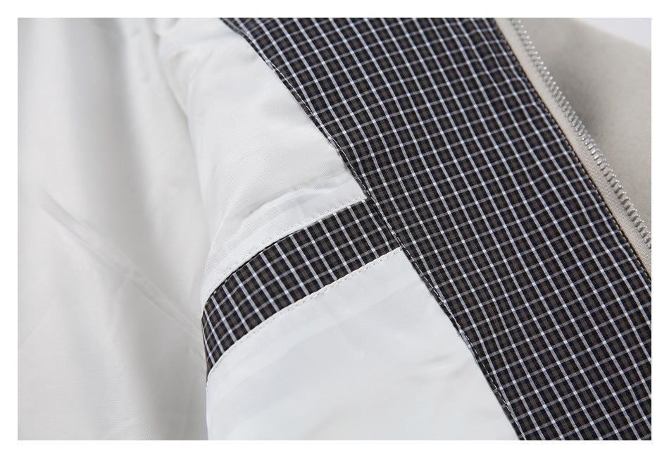 Open beige jacket showing smooth white lining and a black-and-white checked inner panel.