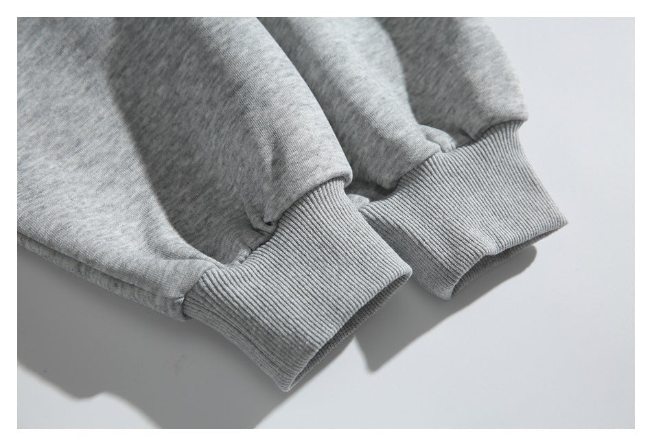 Close-up of two ribbed cuffs on the sleeves of a heather-gray sweatshirt.