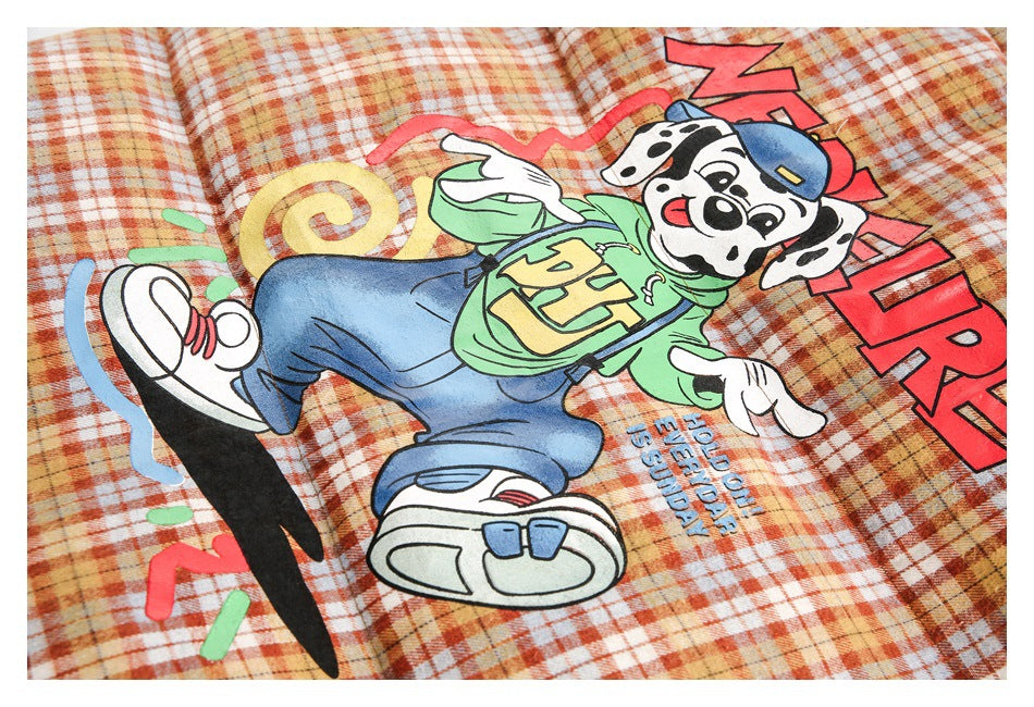 Close-up of a colorful cartoon dog graphic with English lettering printed on orange plaid fabric.