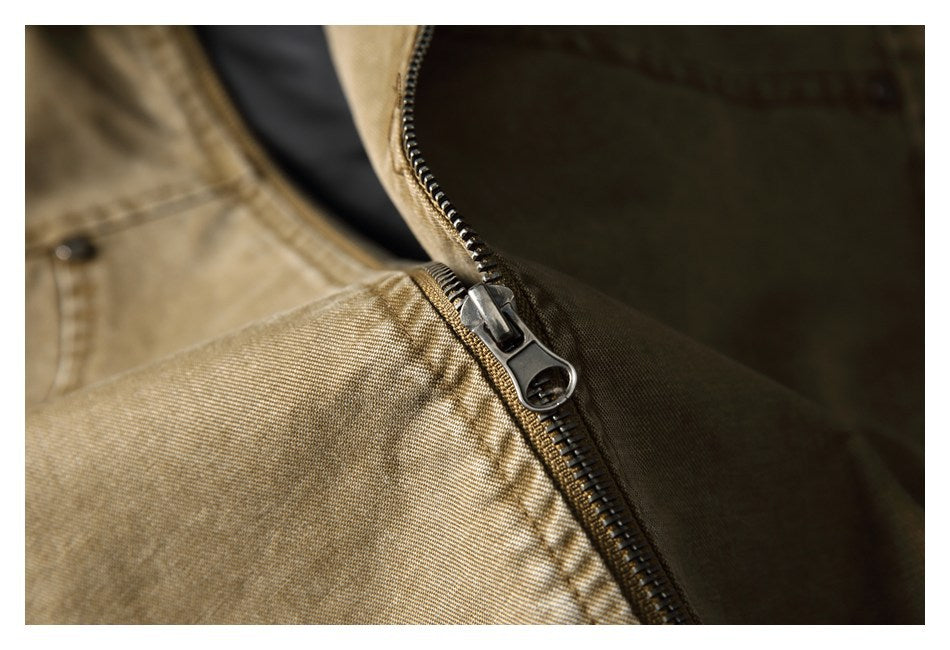 Close-up of the metal zipper and pull on a tan-brown jacket against its dark lining.