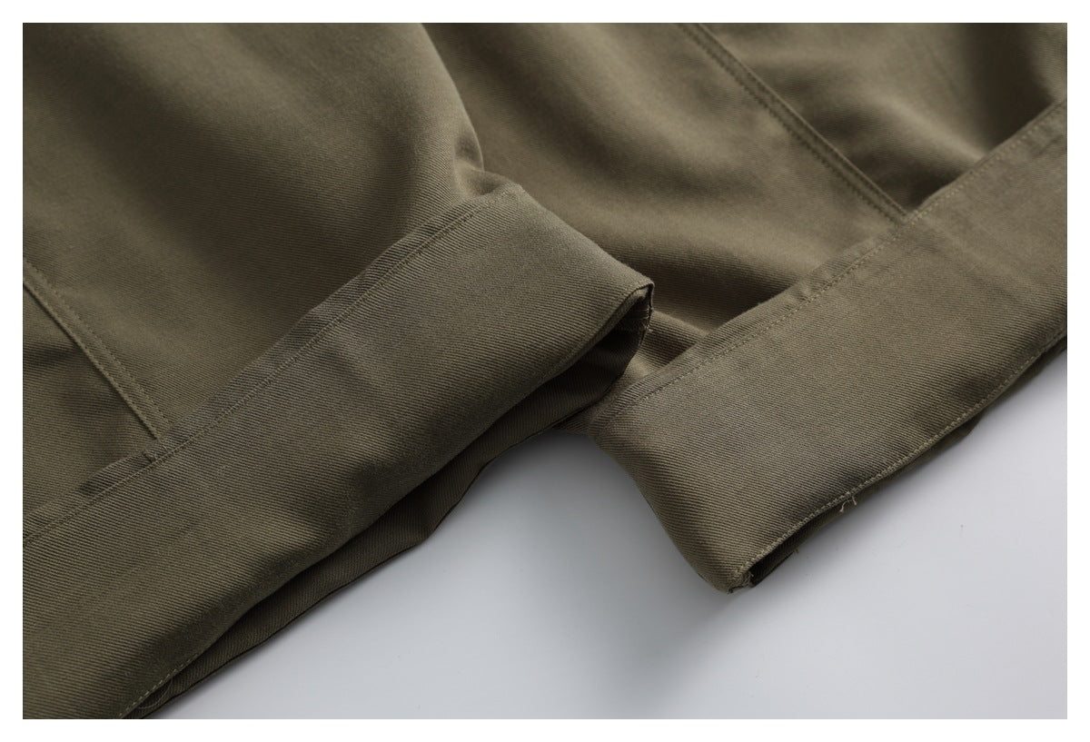 Close-up of olive-brown trouser legs showing folded hems and parallel stitching.