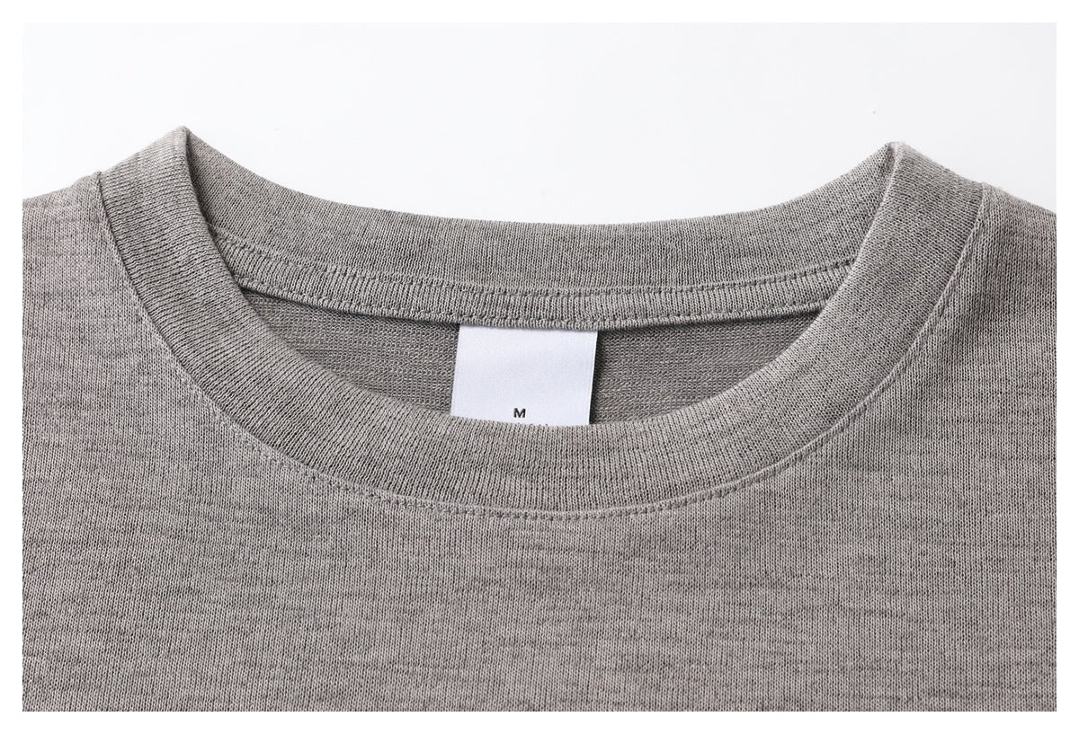 Close-up of a gray T-shirt's crew neck, stitching, and inner size tag marked M.