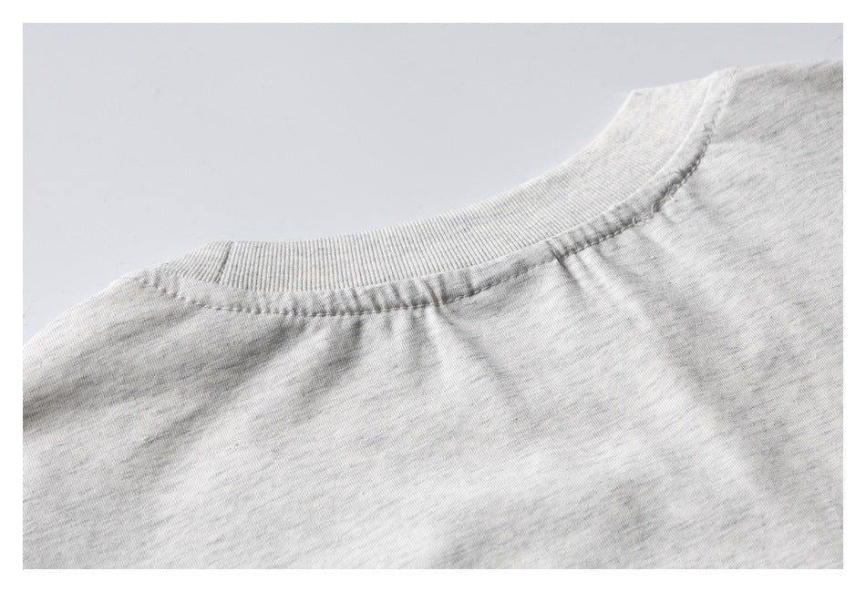 Close-up of the ribbed back collar and shoulder seam on a light heather-gray T-shirt.