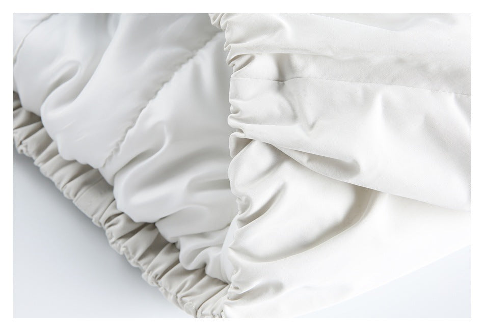 Close-up of gathered elastic cuffs on a white jacket sleeve.