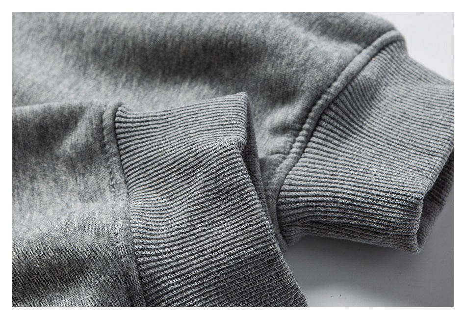 Close-up of a heather-gray sweatshirt with ribbed cuffs and seam details.