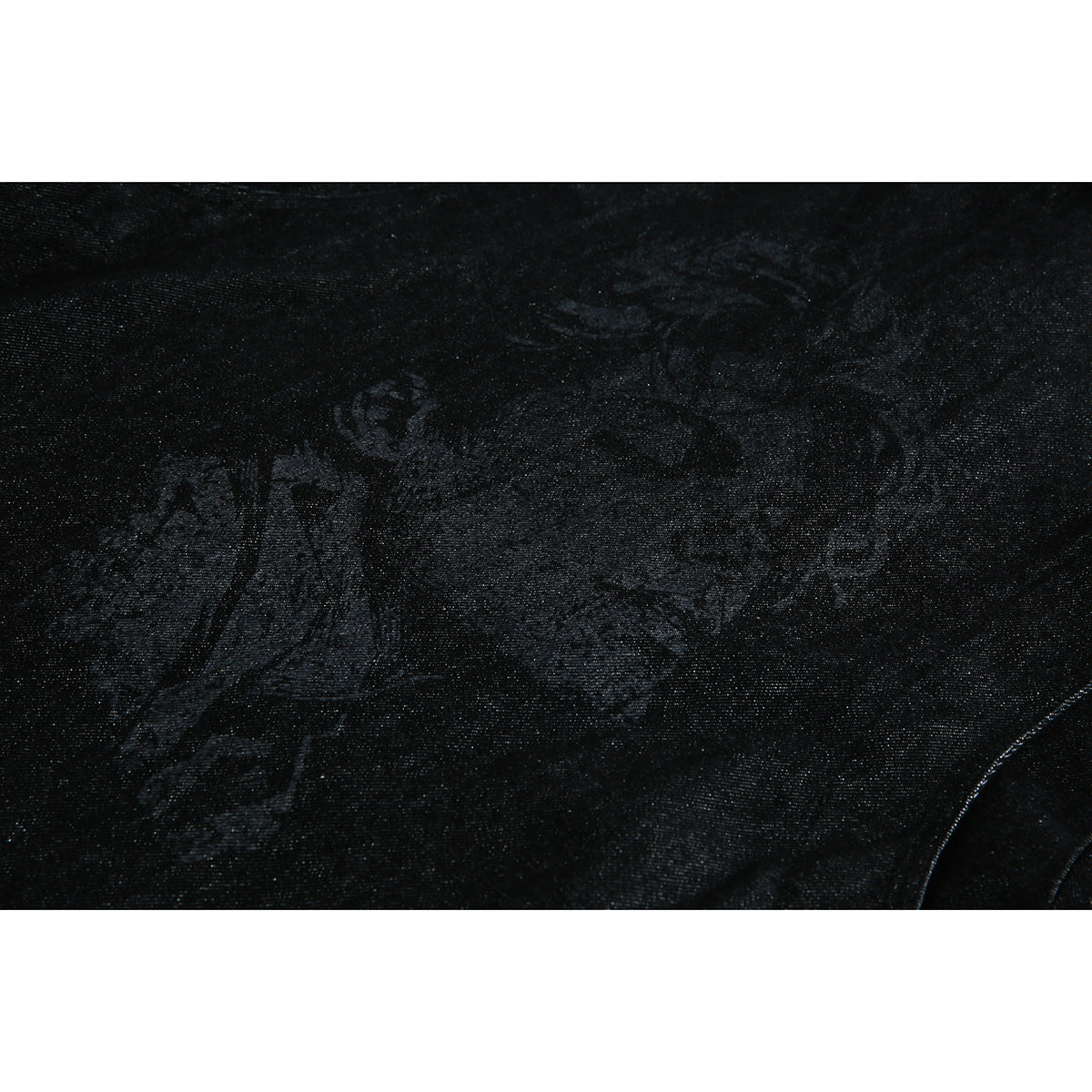 Close-up of black textured jacket fabric with a subtle dark portrait graphic.