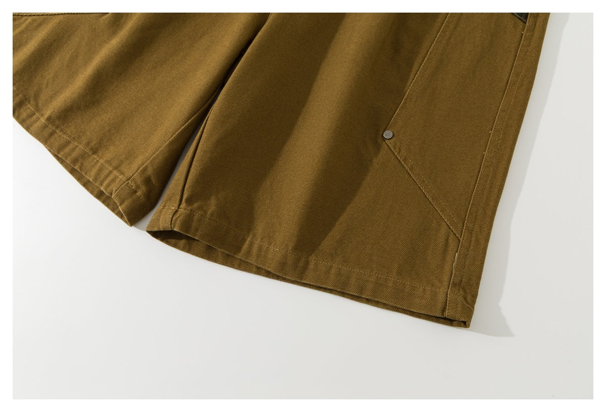 Close-up of the mustard-brown shorts' leg hem and seam detailing.