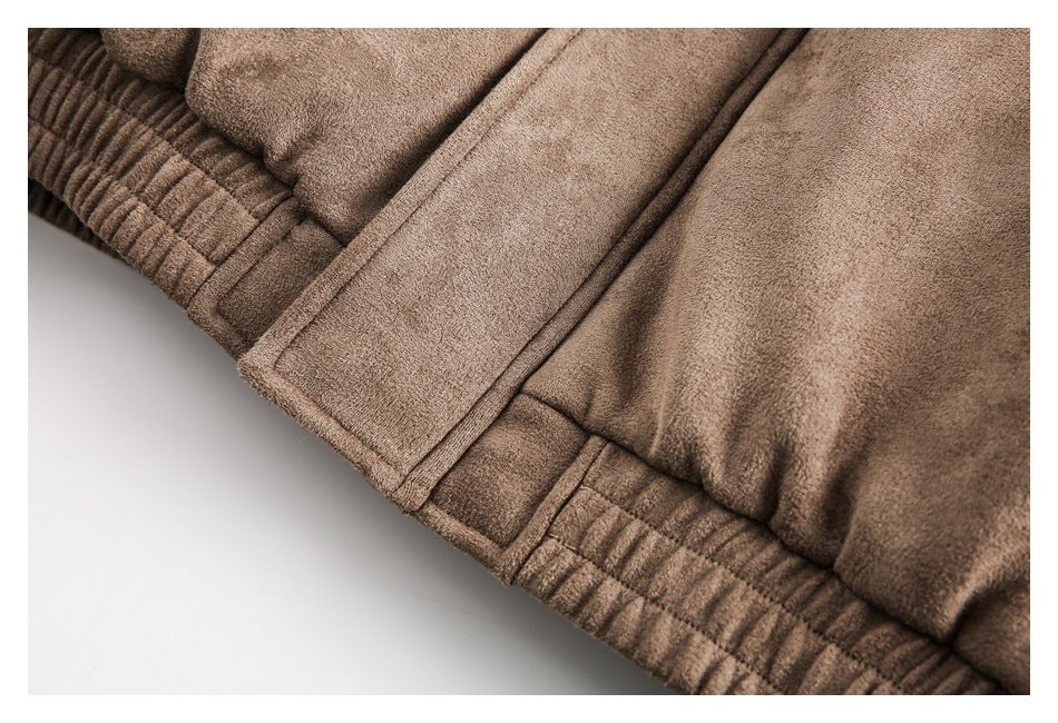 Close-up of the brown jacket's stitched lower panel and gathered elastic edge.