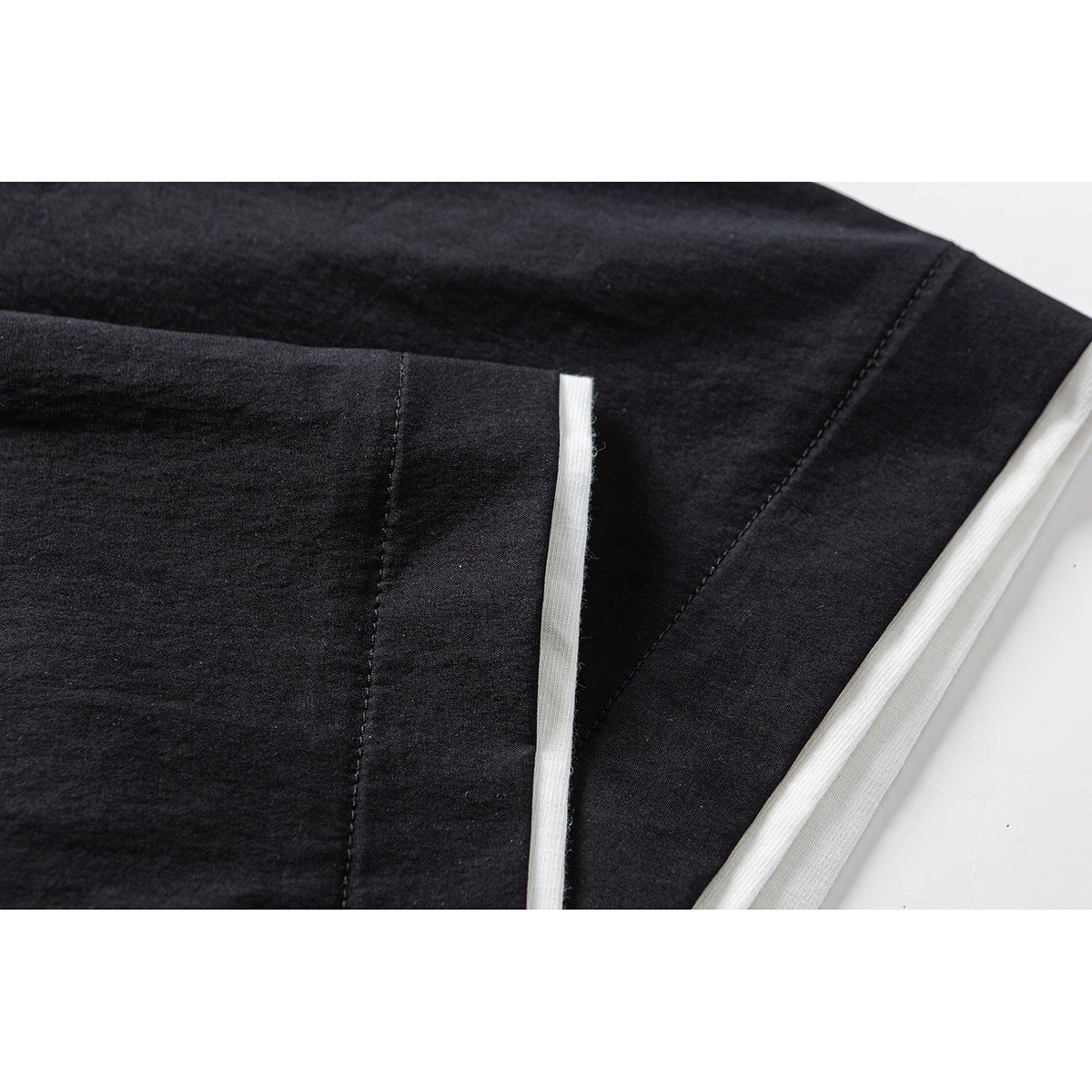 Close-up of black garment seams and a narrow white inner edge along a folded section.