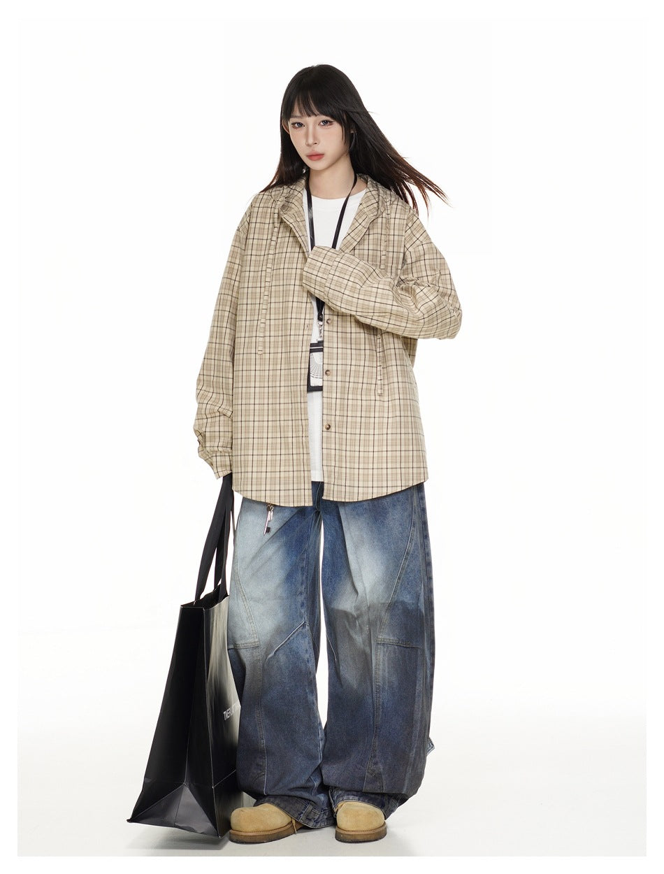 Model wearing oversized khaki plaid hooded shirt over a white tee with a lanyard, wide-leg jeans and a black tote