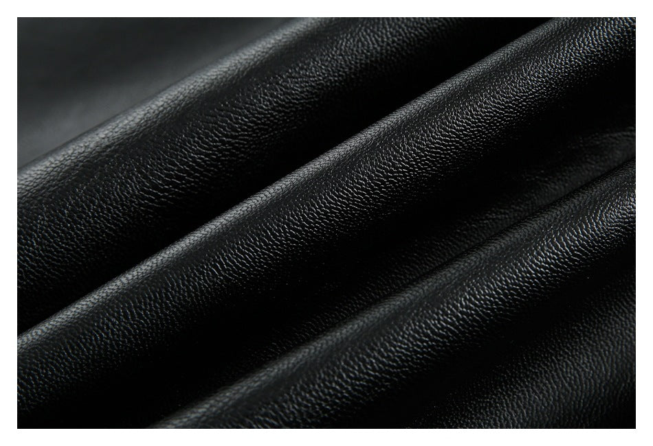 Extreme close-up of the pebbled texture and folds of black jacket material.