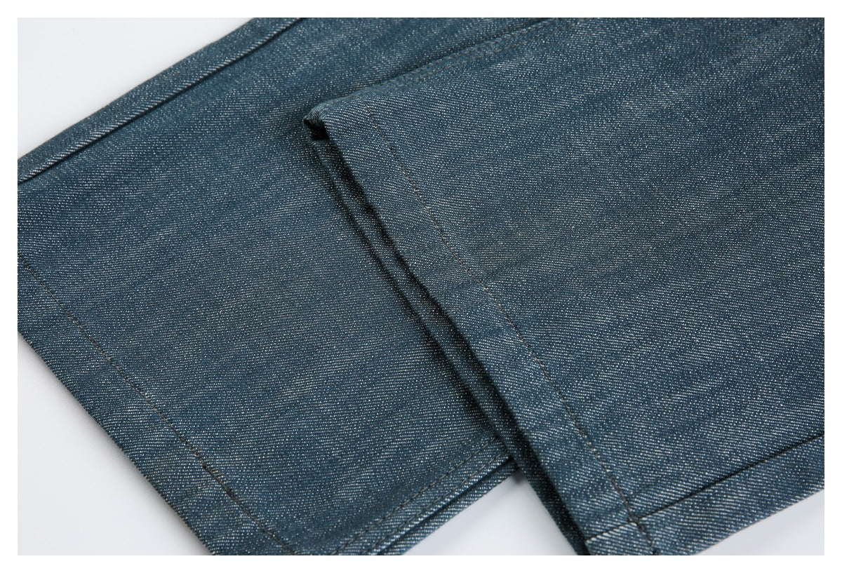 Close-up of blue denim garment hem with double stitching and a folded edge.