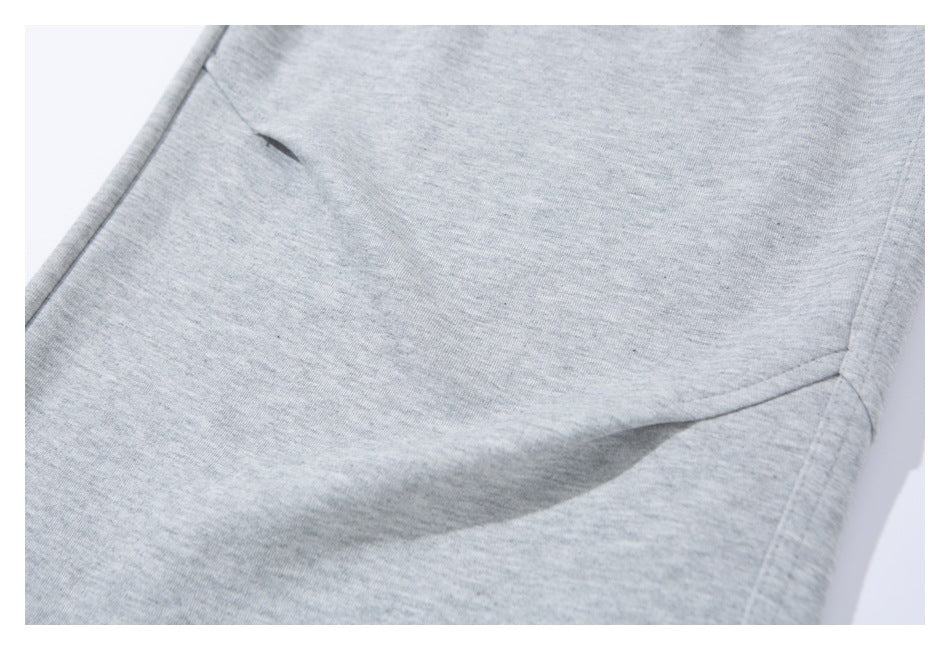 Close-up of light gray sweatpants fabric and curved stitched seam.