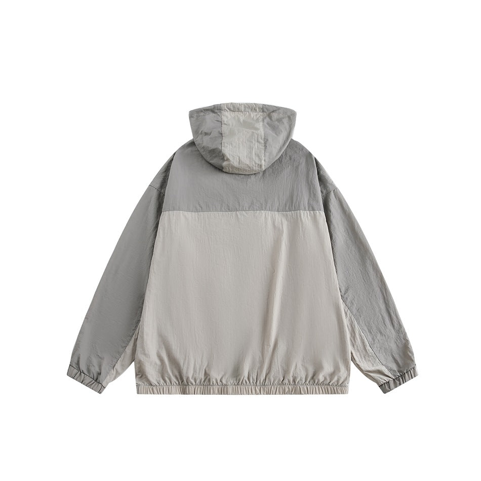 Back view of a light gray and beige color-block hooded jacket with elastic cuffs and hem.