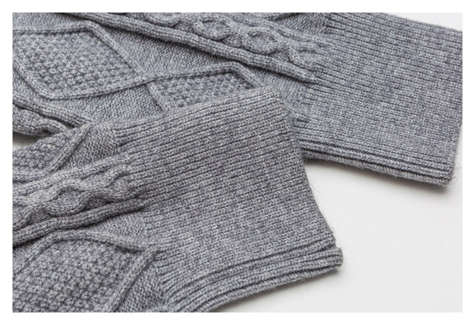 Close-up of gray sweater sleeves and ribbed cuffs with cable-knit detailing.