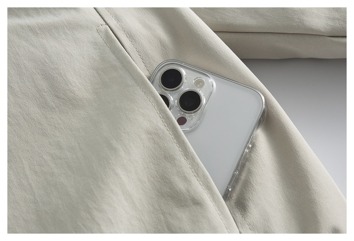 Close-up of a phone tucked into the angled pocket of a light beige jacket.