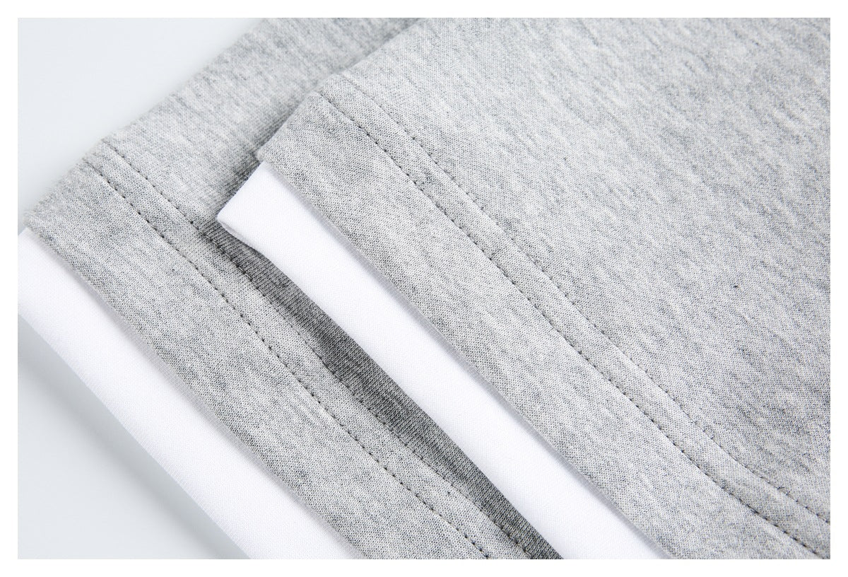 Close-up of heather gray garment edges with parallel stitching and a white layer between them.