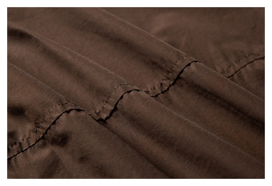 Close-up of dark brown fabric with stitched seams and folded edges.
