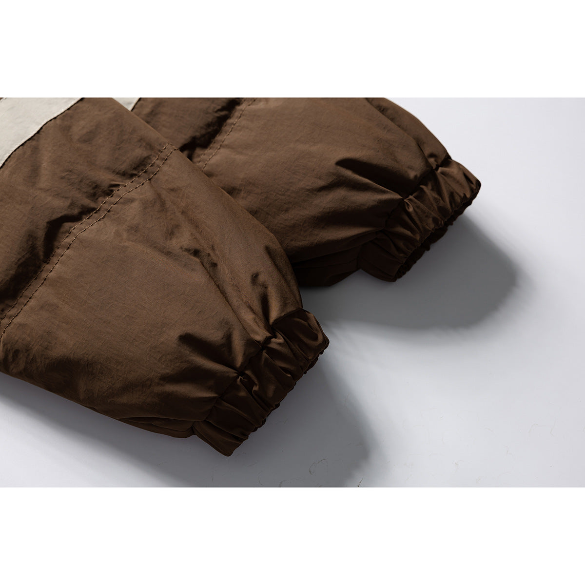 Close-up of the brown jacket's gathered elastic sleeve cuffs and stitched seams.