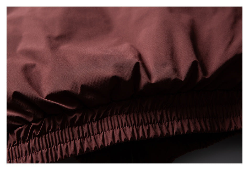 Close-up of gathered elastic stitching along the hem of a burgundy garment.