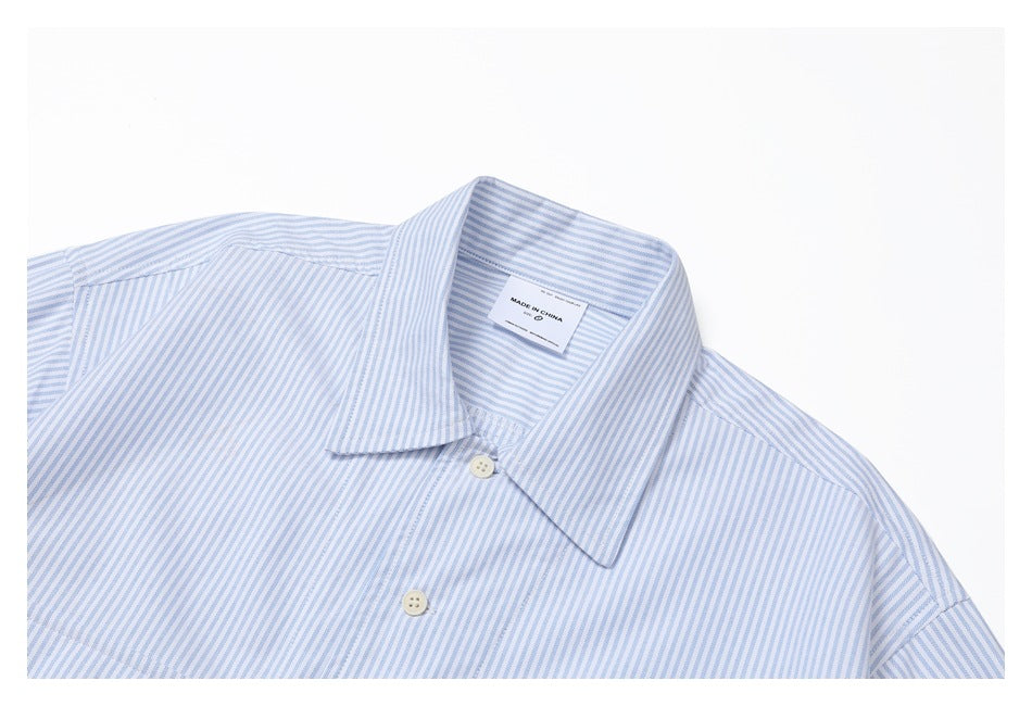 Close-up of a blue-and-white striped shirt collar, buttons, and inner label reading “MADE IN CHINA.”