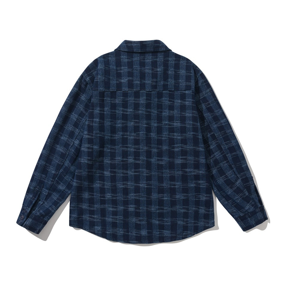 Back view of blue plaid long-sleeve shirt jacket with back yoke seam and curved hem, flat lay