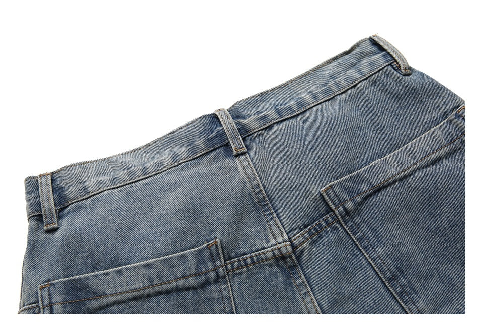 Close-up of the back waistband, belt loops, and upper edge of a pocket on blue washed jeans.