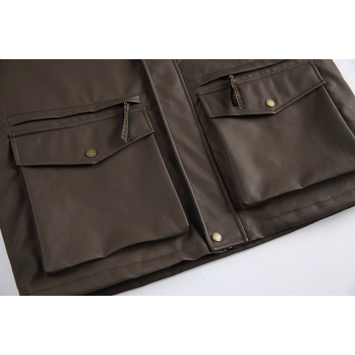 Close-up of the dark brown jacket’s two large flap pockets, horizontal zippers, patterned pulls, and snap buttons.