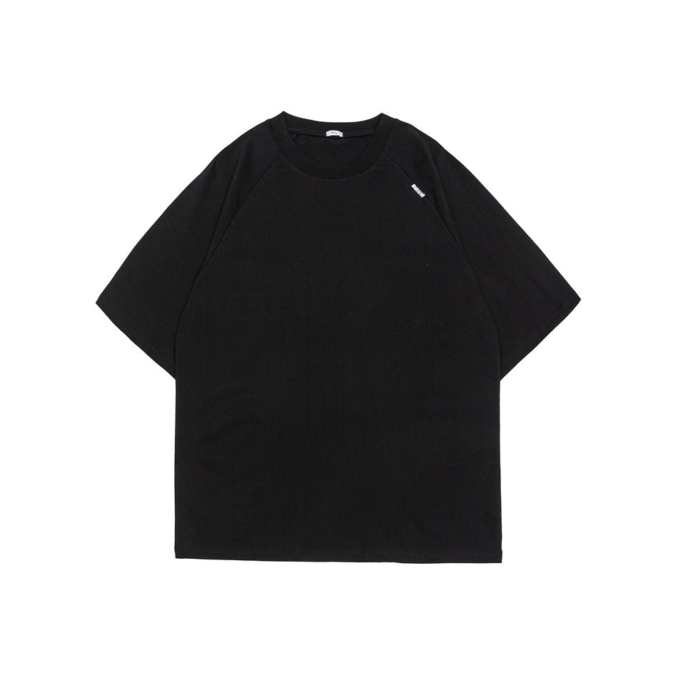 Black short-sleeve crew-neck raglan T-shirt, flat front view with small light embroidered detail near the shoulder