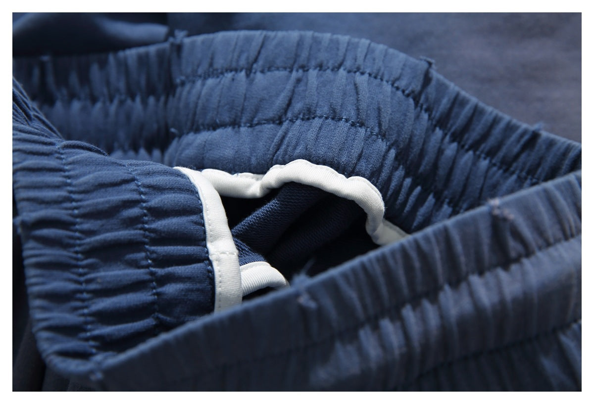 Close-up of a gathered blue elastic waistband with white drawstring details.