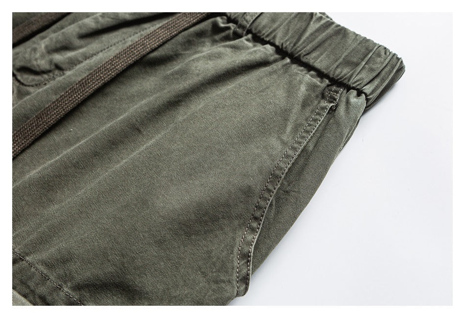Close-up of olive cargo pants showing the side seam, stitching and elastic waistband.