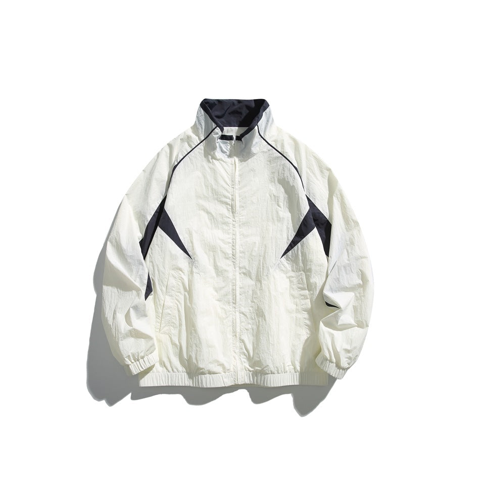 Off-white track-style jacket with navy collar lining and navy side panels, stand collar, front zipper, elastic cuffs and hem