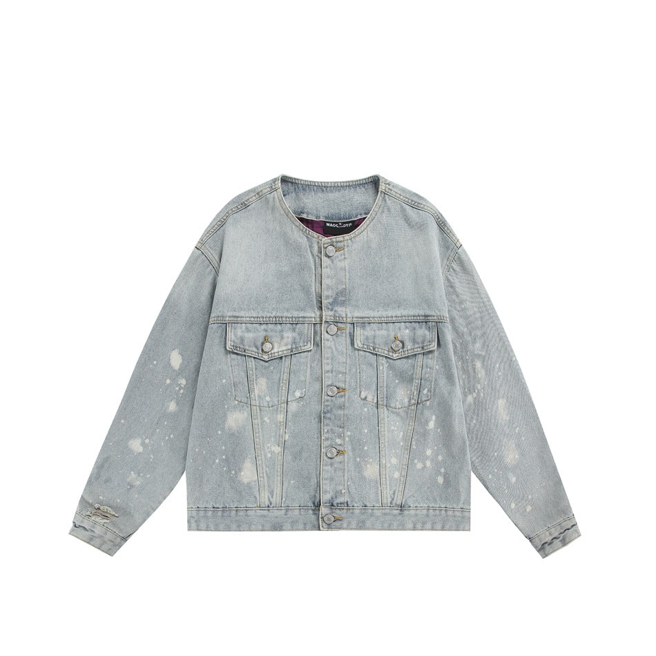 Front view of a light-wash denim jacket with pale splatter marks, two flap chest pockets, and metal buttons.