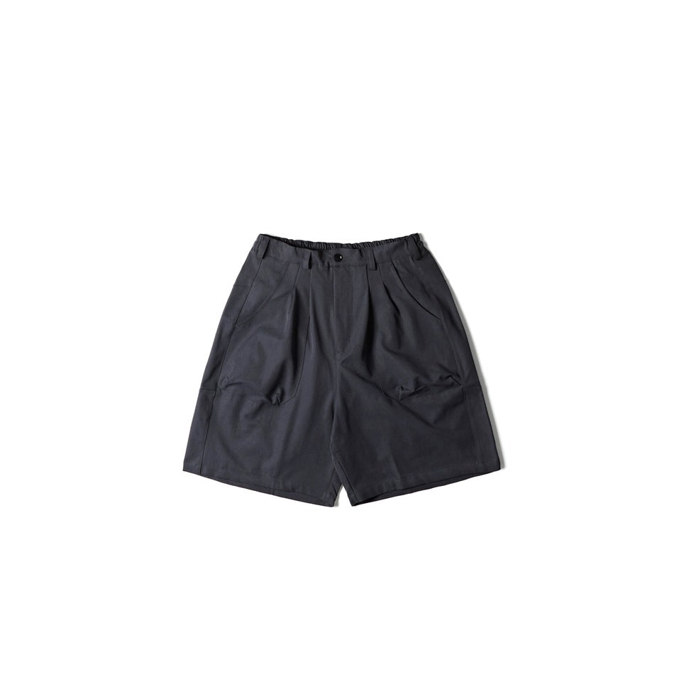 Dark charcoal-black pleated wide-leg shorts with button front, elastic waistband and slanted pockets, flat lay