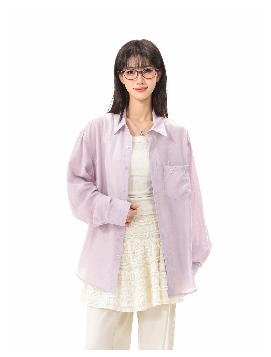 Model wearing a loose pale lavender button-up shirt with a chest pocket over a white top and lace skirt.