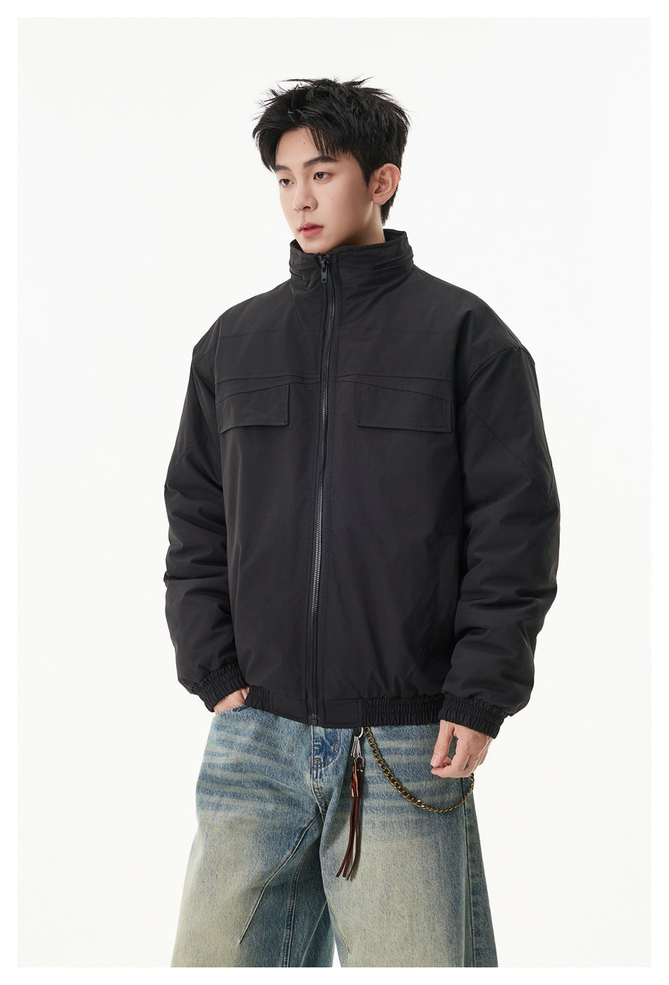 Model wearing a black zip-front jacket with a stand collar and two flap chest pockets.