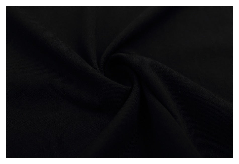 Close-up of black fabric gathered into a swirl, showing its fine texture.