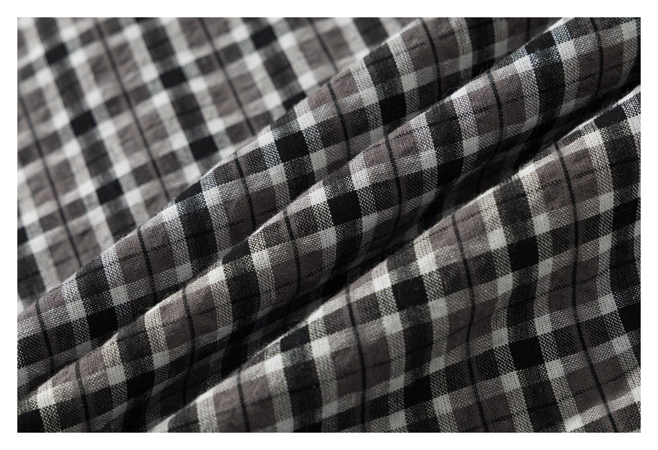Close-up of folded black, gray, and white plaid shirt fabric.