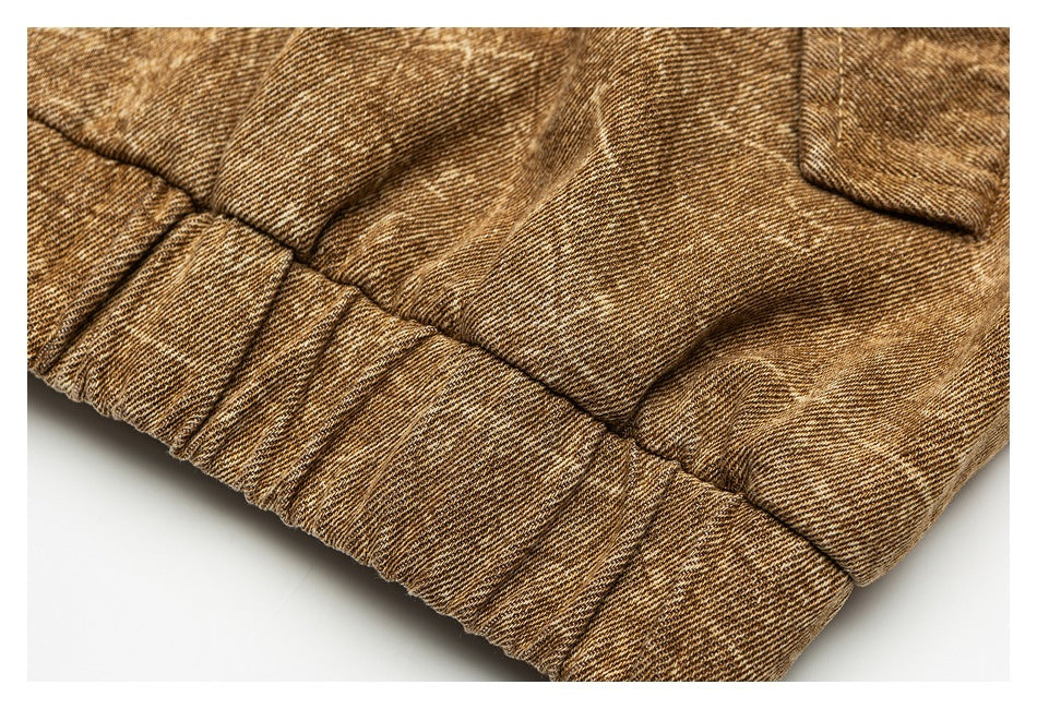Close-up of the jacket's mottled tan fabric, stitching, and gathered elastic hem.