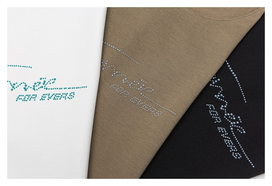 White, taupe, and black garment panels with rhinestone lettering and decorative motifs.