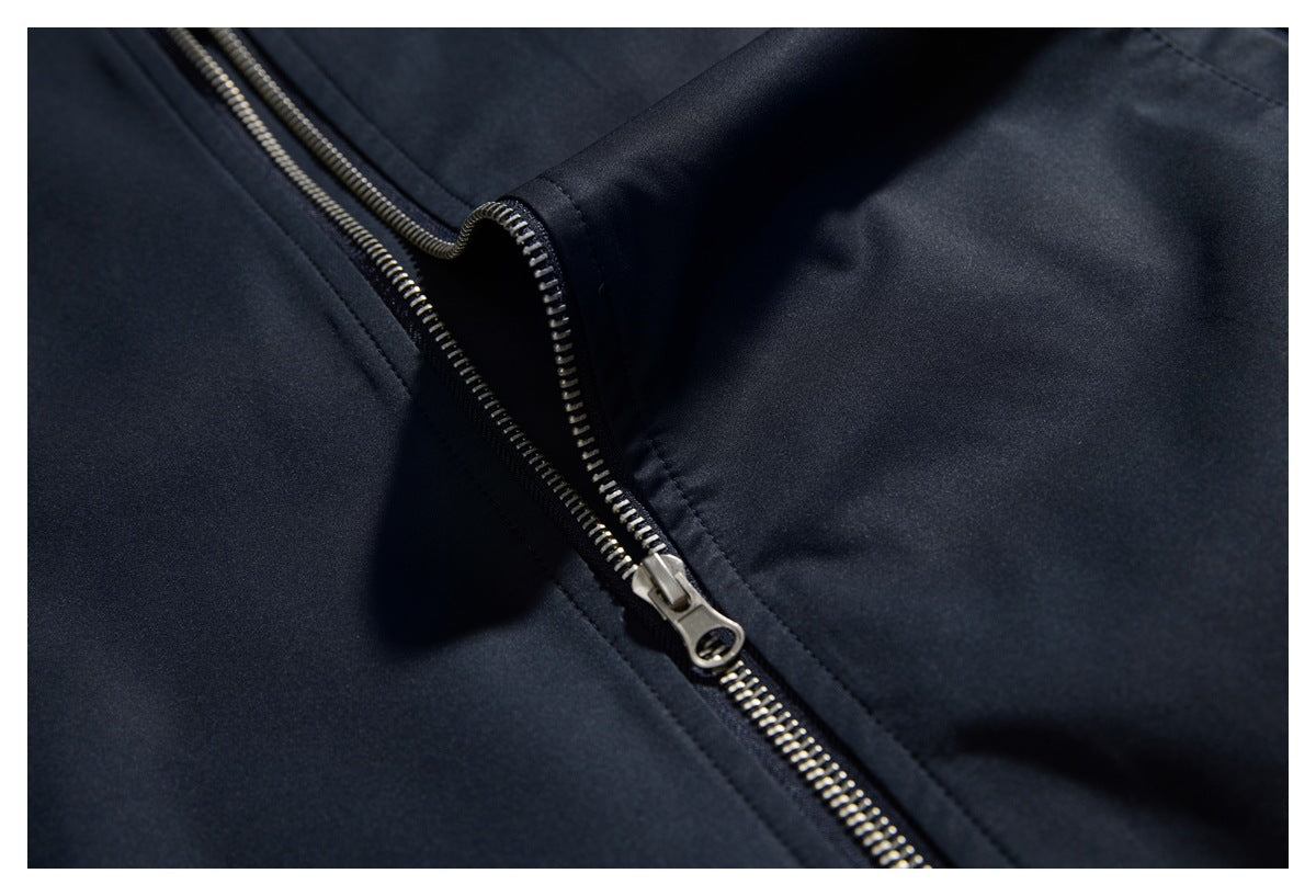 Close-up of the dark navy jacket's partially open metal front zipper.
