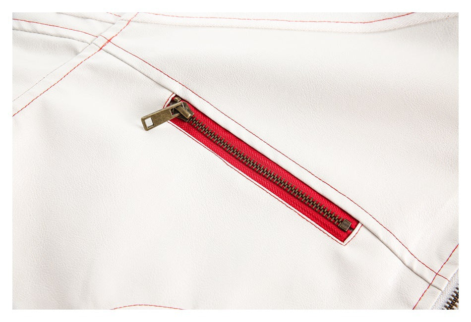 Close-up of a diagonal red-trimmed pocket zipper with brass teeth on the white jacket.