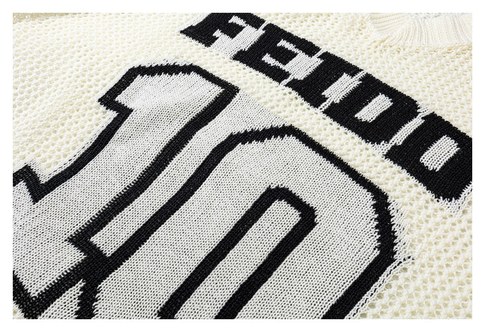 Close-up of the ivory open-knit jersey showing black FEIDD lettering and the outlined number 10 graphic.