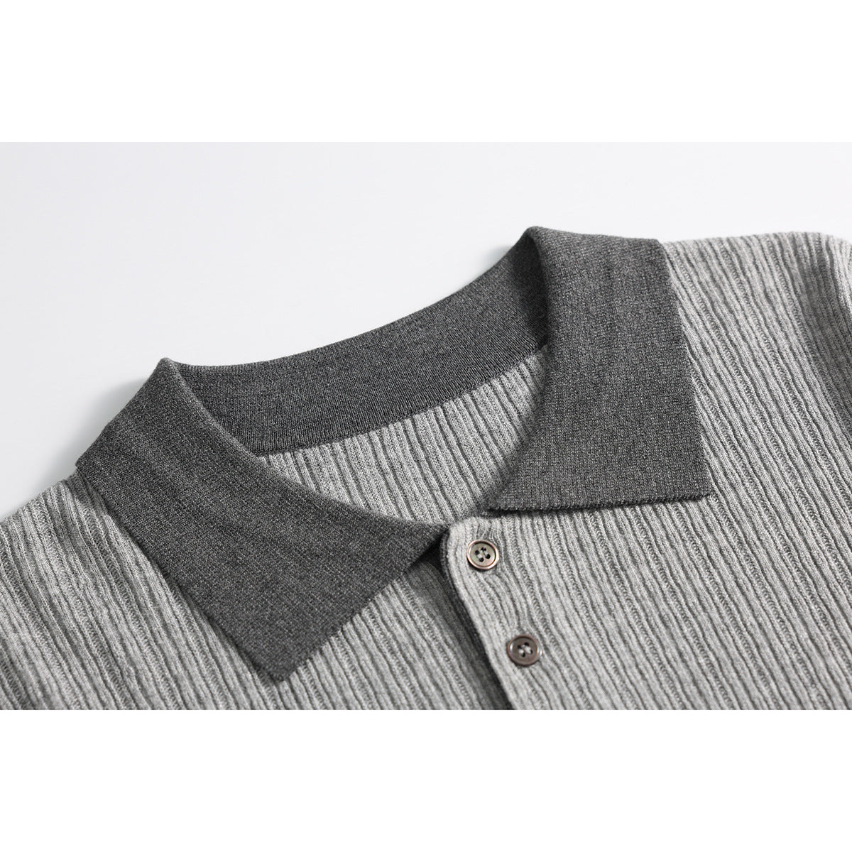 Close-up of a gray ribbed knit polo shirt collar, dark contrast trim, and two buttons.