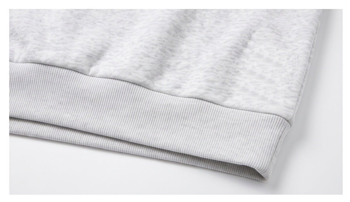 Close-up of a light gray marled garment’s wide ribbed hem band.